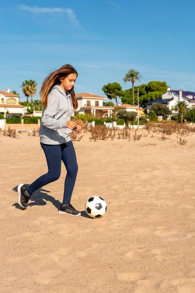 La niña feliz en la playa juega con una pelota en la arena. Viajes y ocio — Foto de Stock