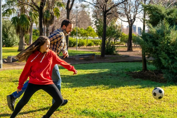 Vader met een kleine dochter die met een bal speelt in de lente natuur. Sport concept — Stockfoto