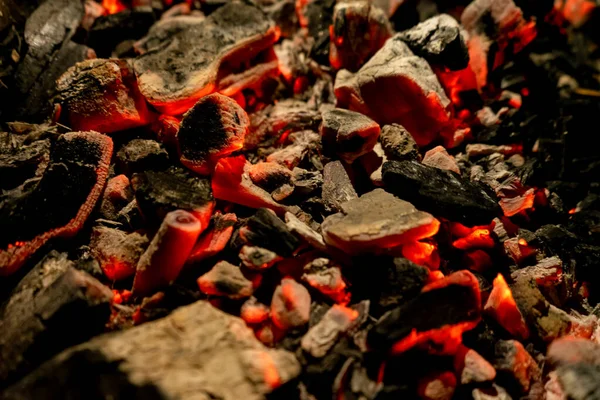 Background of burning and glowing embers. smoldering embers of fire. flicker of burning coals at night. Selective focus.