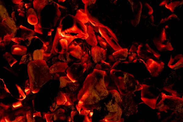 Žhnoucí uhlíky v horké červené barvě, abstraktní pozadí. Horké uhlíky hořících dřevěných polen. Pálení dřeva na grilu. Textura ohně ohně uhlíky — Stock fotografie