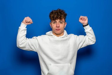 Mutlu kıvırcık adam formda ve sağlıklı bir hayat sürüyor. Kaslarını esneten neşeli beyaz bir adam. Güç ve kendini beğenmişlik kavramı.