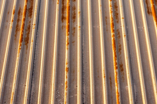 Фон из ржавого металла, установленного на потолке завода в панелях с вертикальными линиями.
