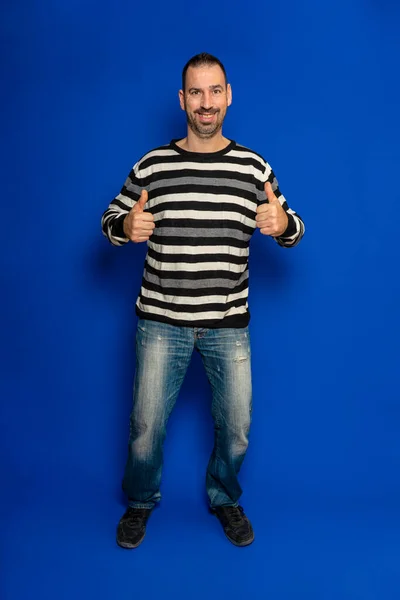 Cheerful Excited Man Striped Pullover Posing Isolated Blue Wall Background — Stok fotoğraf