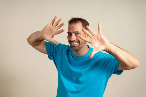 Homem Hispânico Vestindo Uma Camiseta Azul Sobre Fundo Bege Isolado — Fotografia de Stock