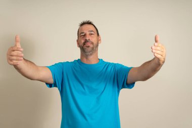 Kötü bir gün geçiren kişiye bedava sarılma. Mavi tişörtlü neşeli arkadaş canlısı erkek model, kameraya doğru elini çekiyor, sarılmak istiyor, geniş bir gülümseme içinde, kollarına almak için dostunu selamlıyor.