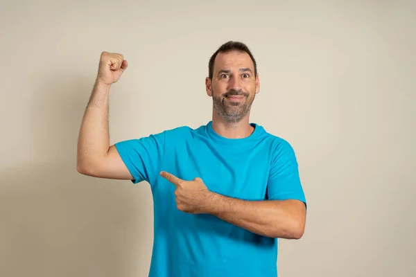 Handsome Funny Bearded Hispanic Man Pointing His Biceps Smiling Beige — Stock Photo, Image