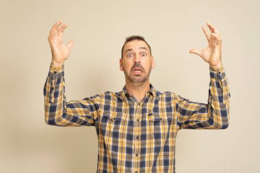 Hayal kırıklığına uğramış, sakallı, elleri havada, hayal kırıklığına uğramış ve şok olmuş bir adam.