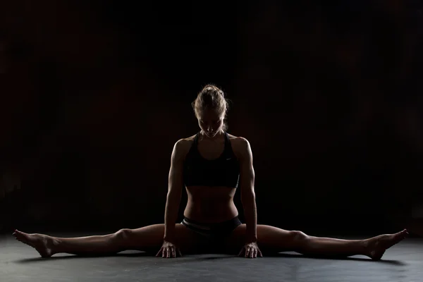 Foto de estudio del instructor de fitness estirando sus divisiones medias Imagen De Stock