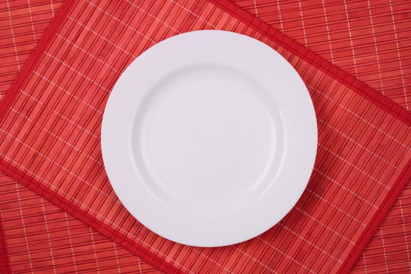 White empty plate on a red — Stock Photo, Image