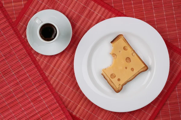 Broodje kaas en een kopje zwarte koffie — Stockfoto