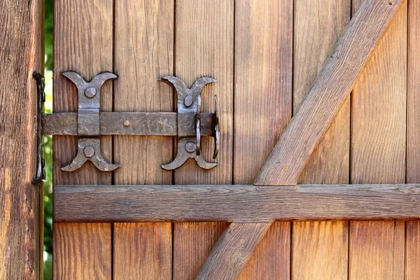 Fechamento de parafuso forjado de metal em uma porta de madeira — Fotografia de Stock