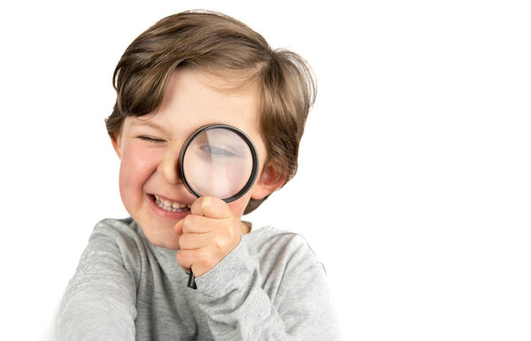 Child investigating with a magnifying glass on a white background.
