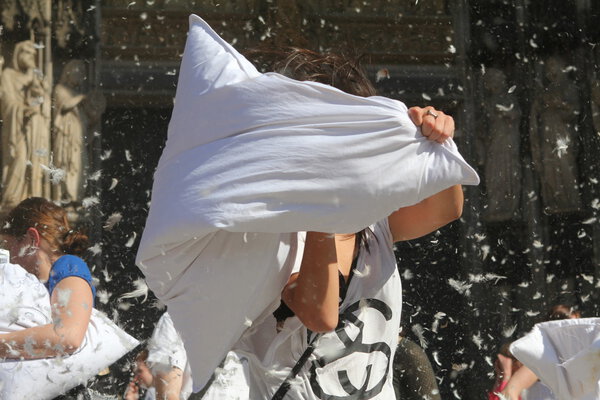 Битва подушками, женщина, бьющая белой подушкой
