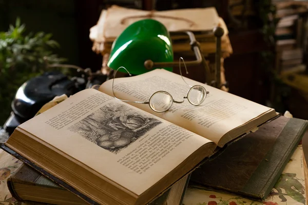 Старі круглі окуляри на книгах, адвокатська лампа та друкарська машинка, старі старі добрі часи Стокове Зображення