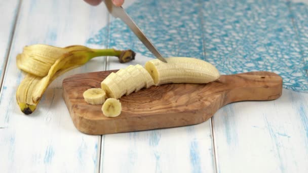 부엌에 나무판에서 바나나를 자르는 — 비디오