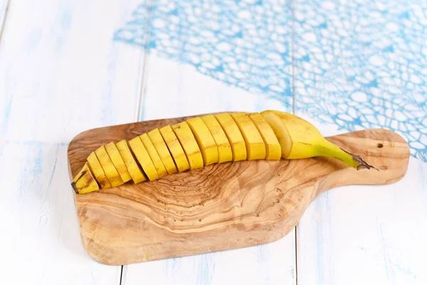 Kesme tahtasındaki kabukla muzu kes.