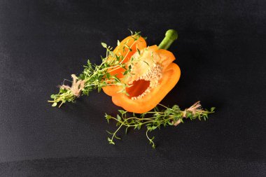 Koyu arkaplanda kekik filizi olan paprika..