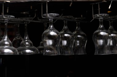 Boş bardaklar barın üstünde baş aşağı asılı.