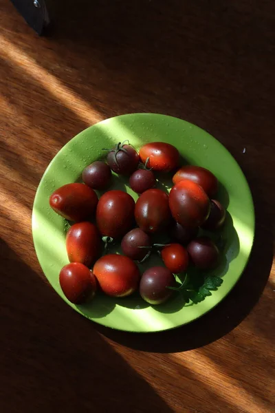 太陽の下で緑のプレート上の赤いトマト — ストック写真
