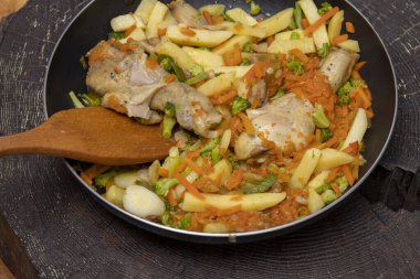 Tavada kızarmış tavuk budu ve patates ve havuç.