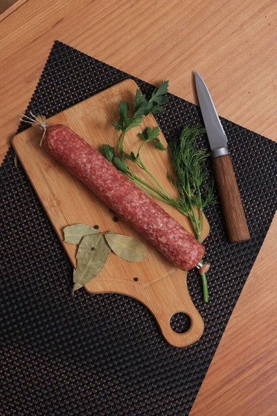 Dry-cured sausage stick on a cutting board