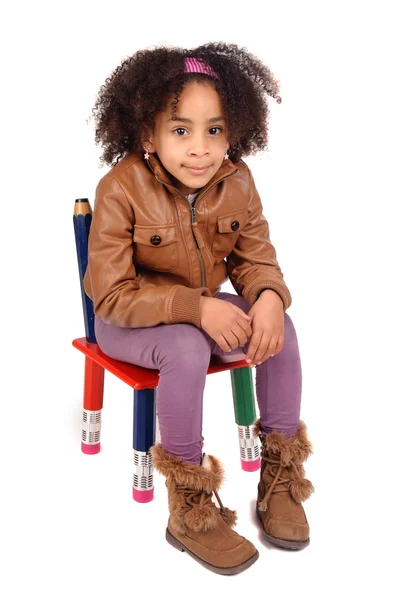 Küçük kız bir sandalyede oturan — Stok fotoğraf
