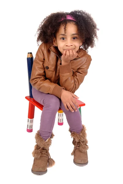 Маленькая девочка сидит в кресле — стоковое фото