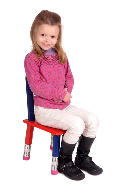 Маленькая девочка сидит в кресле — стоковое фото