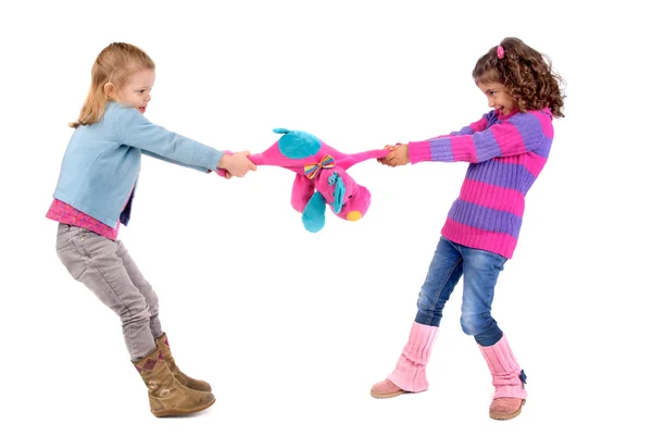 Zwei Mädchen kämpfen um ein Spielzeug — Stockfoto