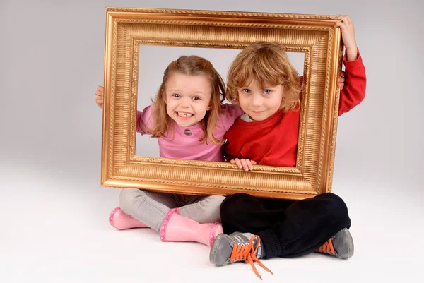 Boy and girl with frame — Stock Photo, Image