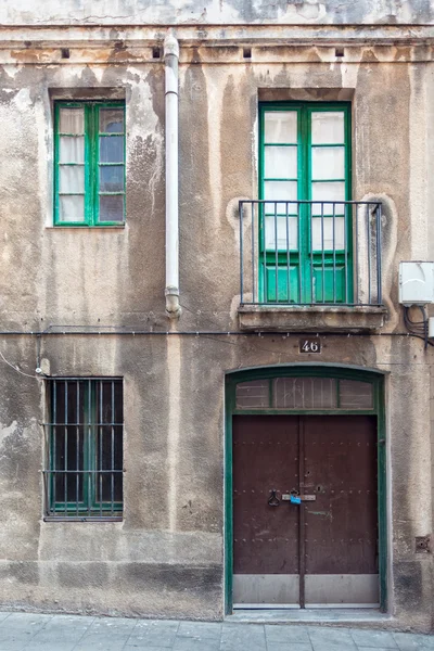 Façade avec porte métallique, fenêtres et balcon — Photo