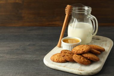 Gri ahşap masada süt, bal ve balkabağı kurabiyeleri.