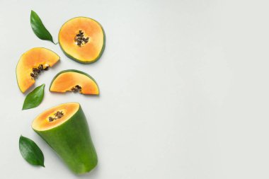 Açık gri zemin üzerinde papaya ile düz yatıyordu