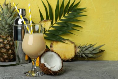 Pina colada kokteyli ve sarı dokulu arka plana karşı malzemeler..
