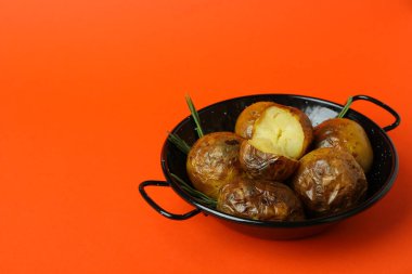 Turuncu arka planda fırında patates..