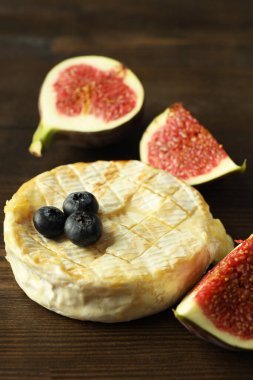 Ahşap arka planda ızgara camembert peynirli lezzetli yemek kavramı.