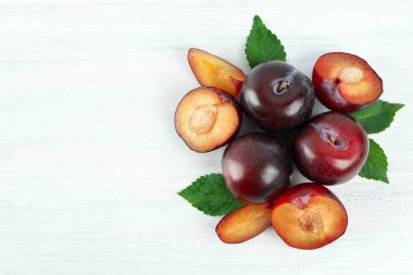 Beyaz ahşap zemin üzerinde erikler ile düz kompozisyon yatıyordu.