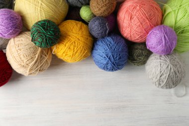 Beyaz ahşap arka planda iplik yumakları.