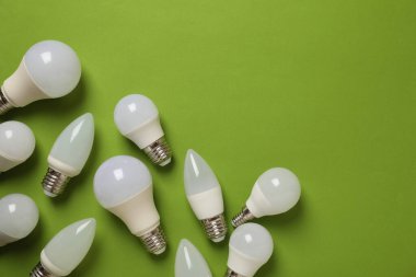 Yeşil arkaplanda enerji tasarrufu ampulleri, metin için boşluk.