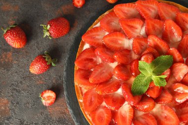 Koyu dokulu masada çilekli tart tepsisi.