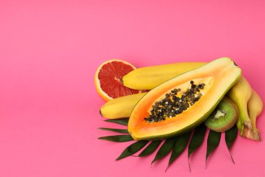 Pembe arkaplanda egzotik meyveler, metin için boşluk.