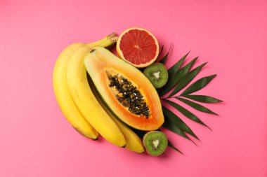 Pembe arka planda taze ve olgun egzotik meyveler..