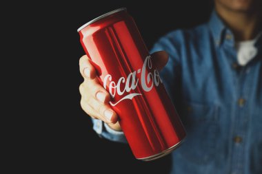 Odessa, Ukrayna - 23 Eylül 2021: Kadın Coca 'yı tutuyor - Siyah arka planda kola kutusu.
