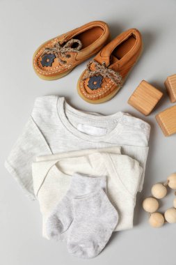 Açık gri arka planda erkek bebek kıyafetleri kavramı.