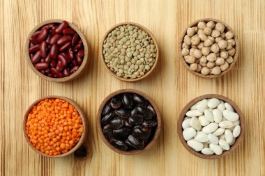 Tahta bir arka planda farklı fasulye türleri ile düz bileşim yatıyordu.