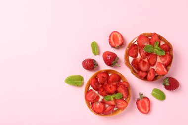 Pembe arkaplanda çilekli turtalar, metin için boşluk.