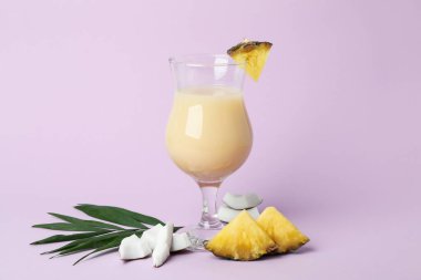 Pina colada kokteyli ve mor arka planda malzemeler.