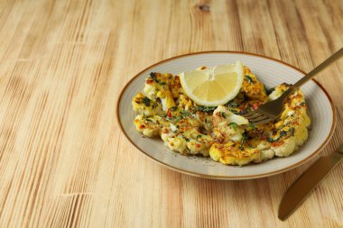 Ahşap arka planda pişmiş karnabahar ile lezzetli yemek kavramı.