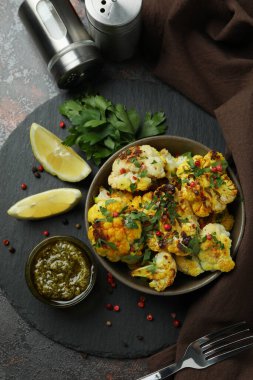 Koyu dokulu arka planda pişmiş karnabahar ile lezzetli yemek kavramı.