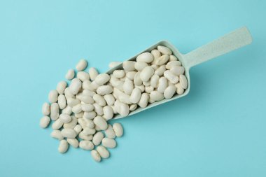 Mavi arka planda beyaz fasulye kepçesi